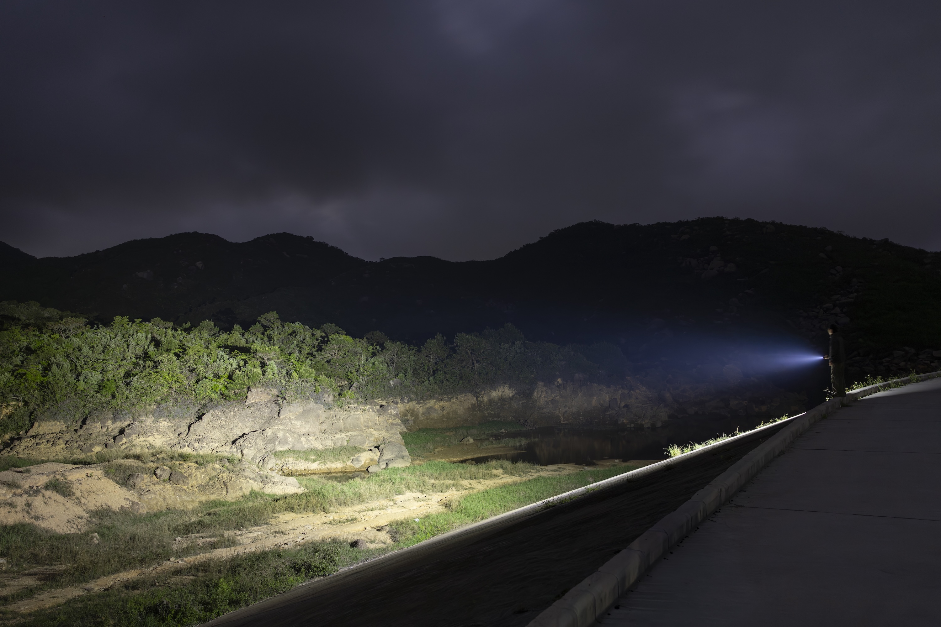 Leistungsstarke LED-Taschenlampe leuchtet weite Naturlandschaft aus