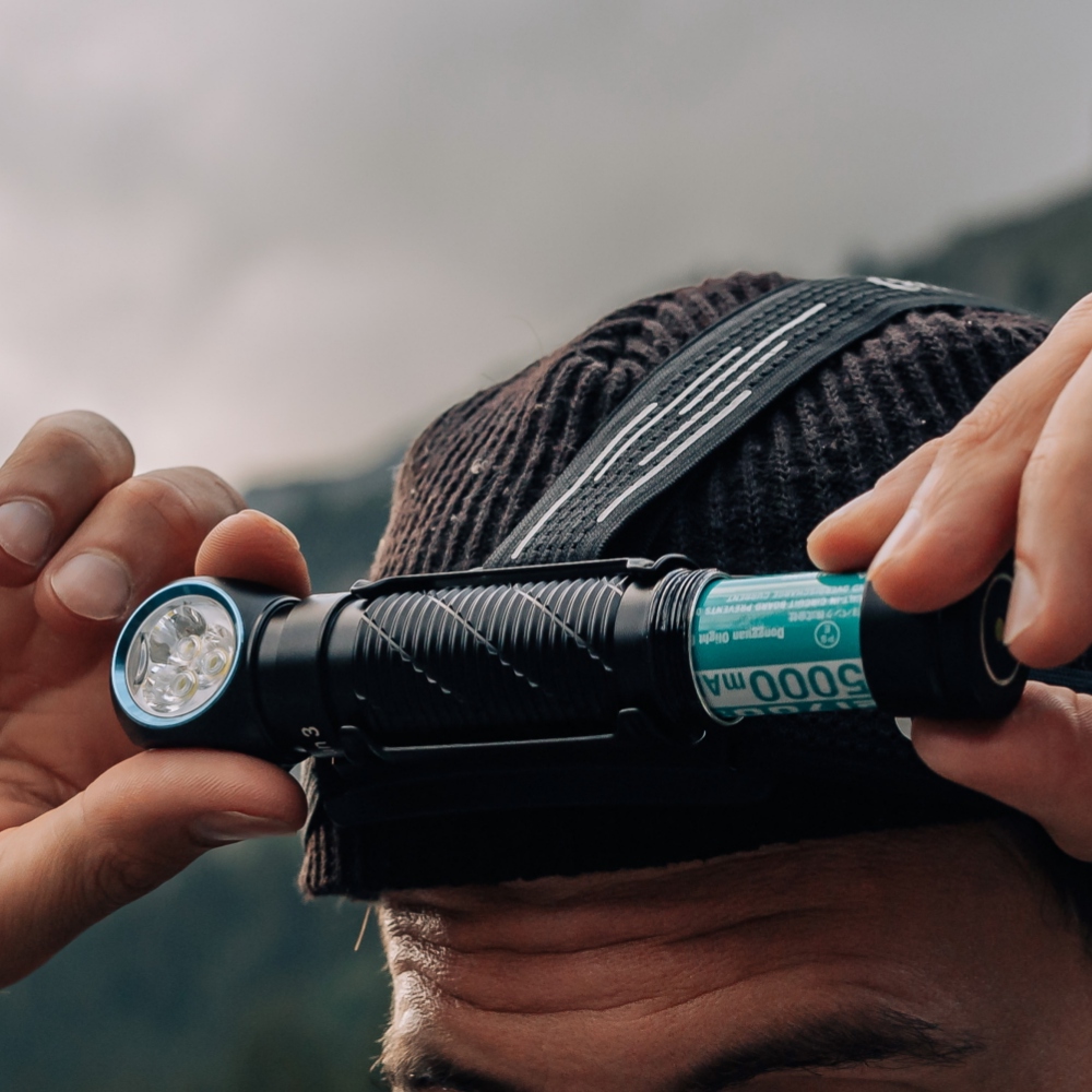 Man inserting a battery into high-performance LED headlamp