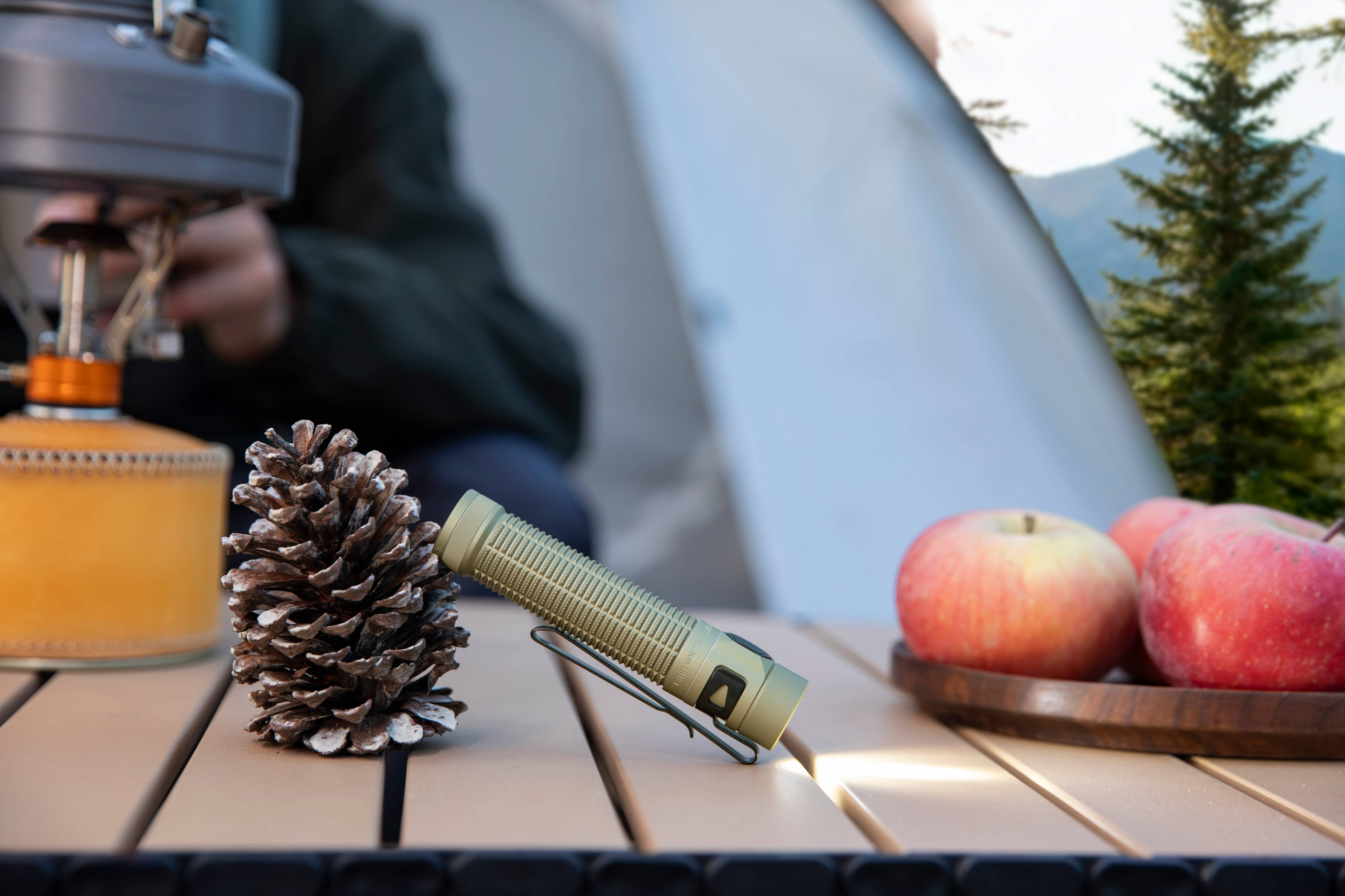 Linterna LED potente Olight Baton Ultra iluminando un mapa en exteriores