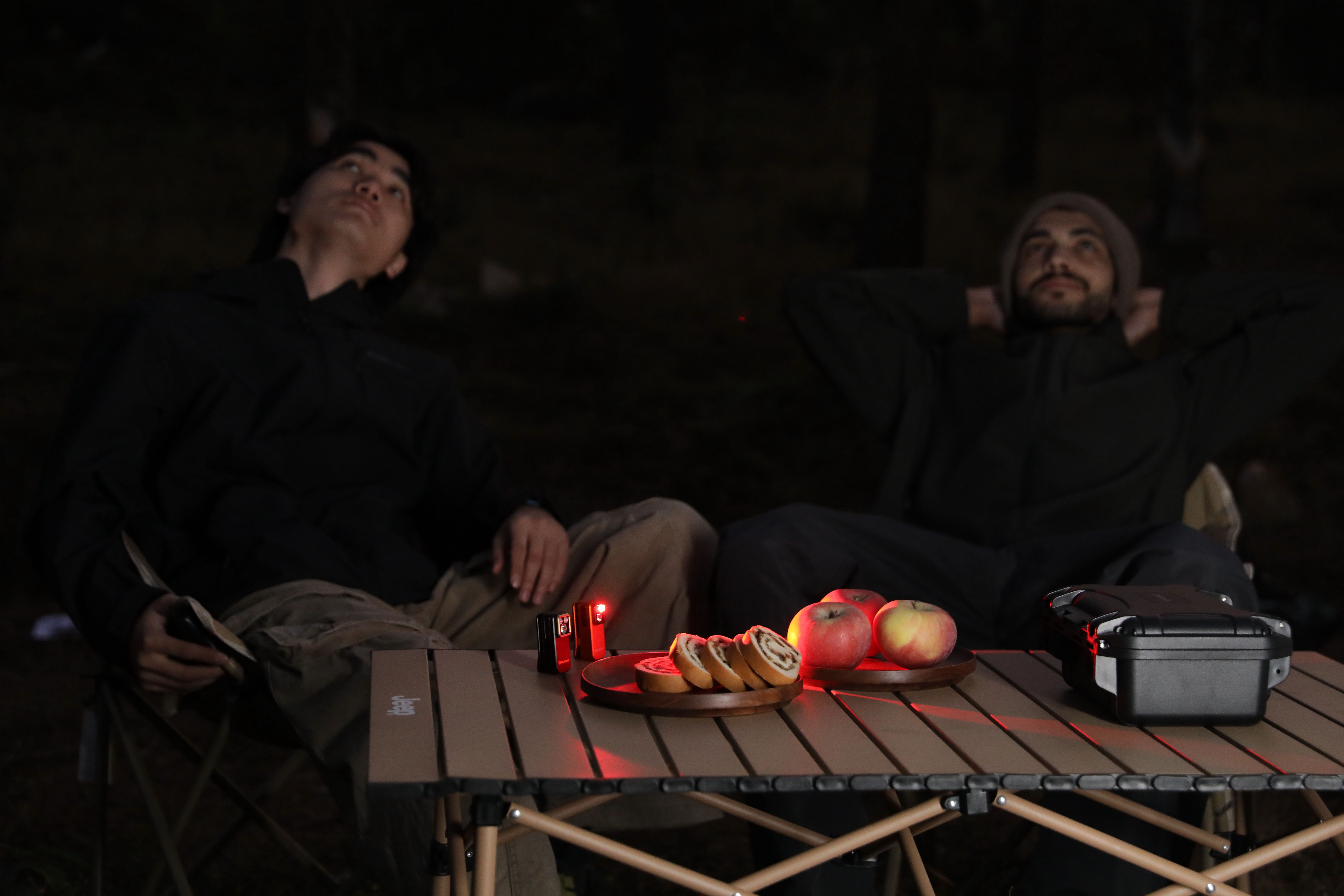 Family enjoying campsite activities under ambient lighting