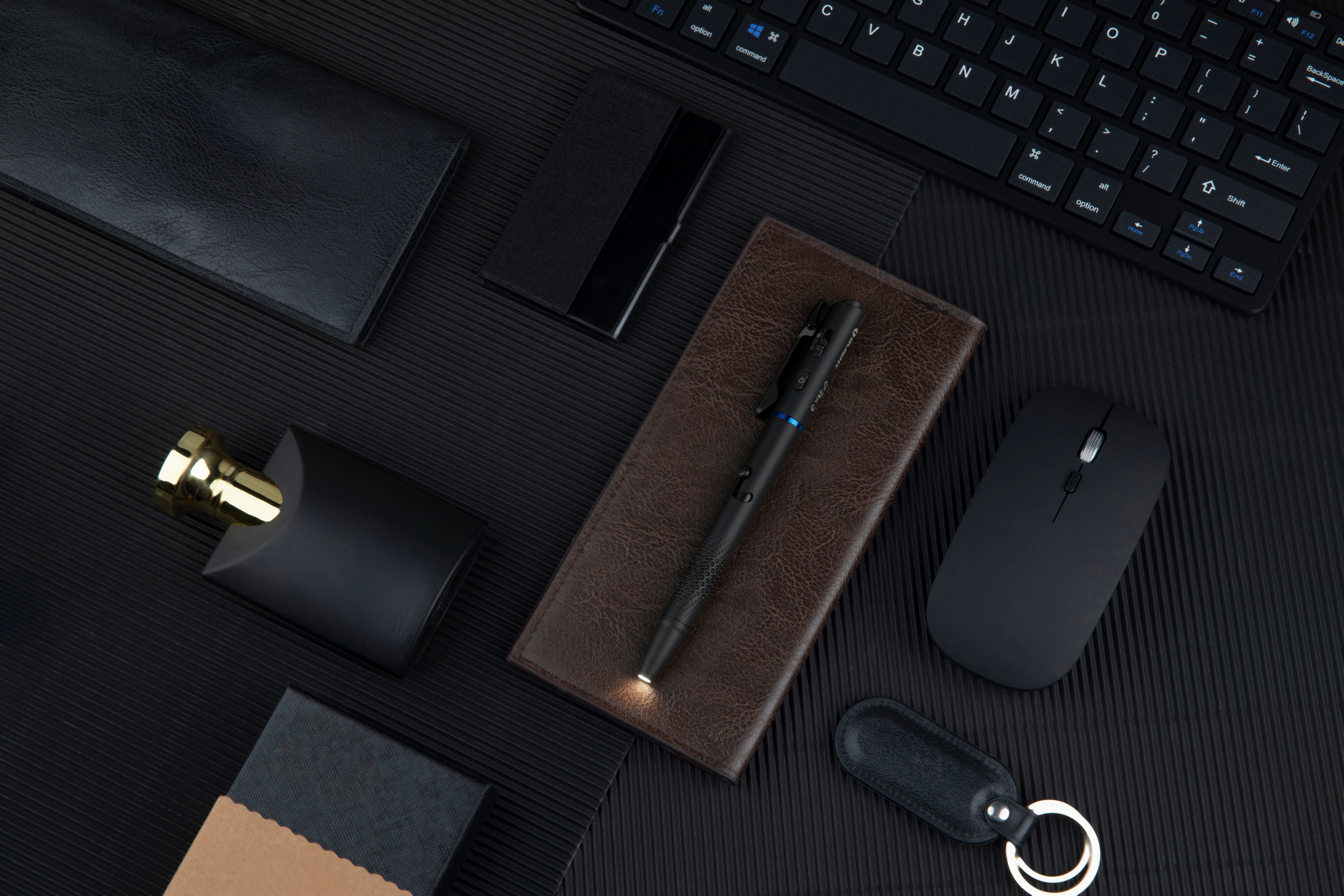 Official product image of a modern black office desk with an Olight pen on a leather notebook.