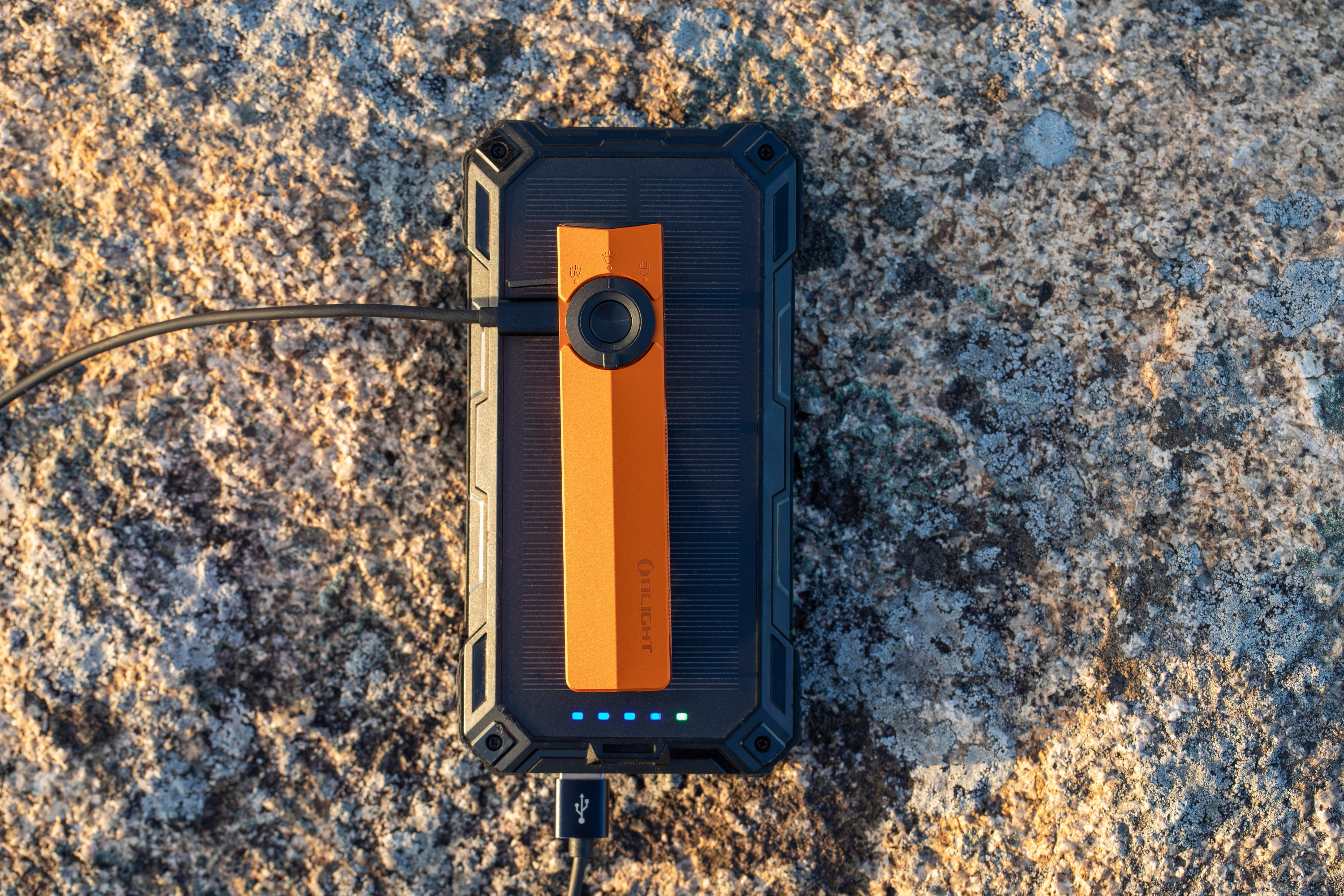 Camping gear and orange Olight EDC flashlight