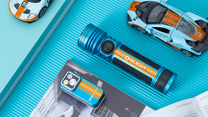 Olight Seeker 4 Pro und Arkfeld LED-Taschenlampen in Blau mit orangefarbenen Streifen.