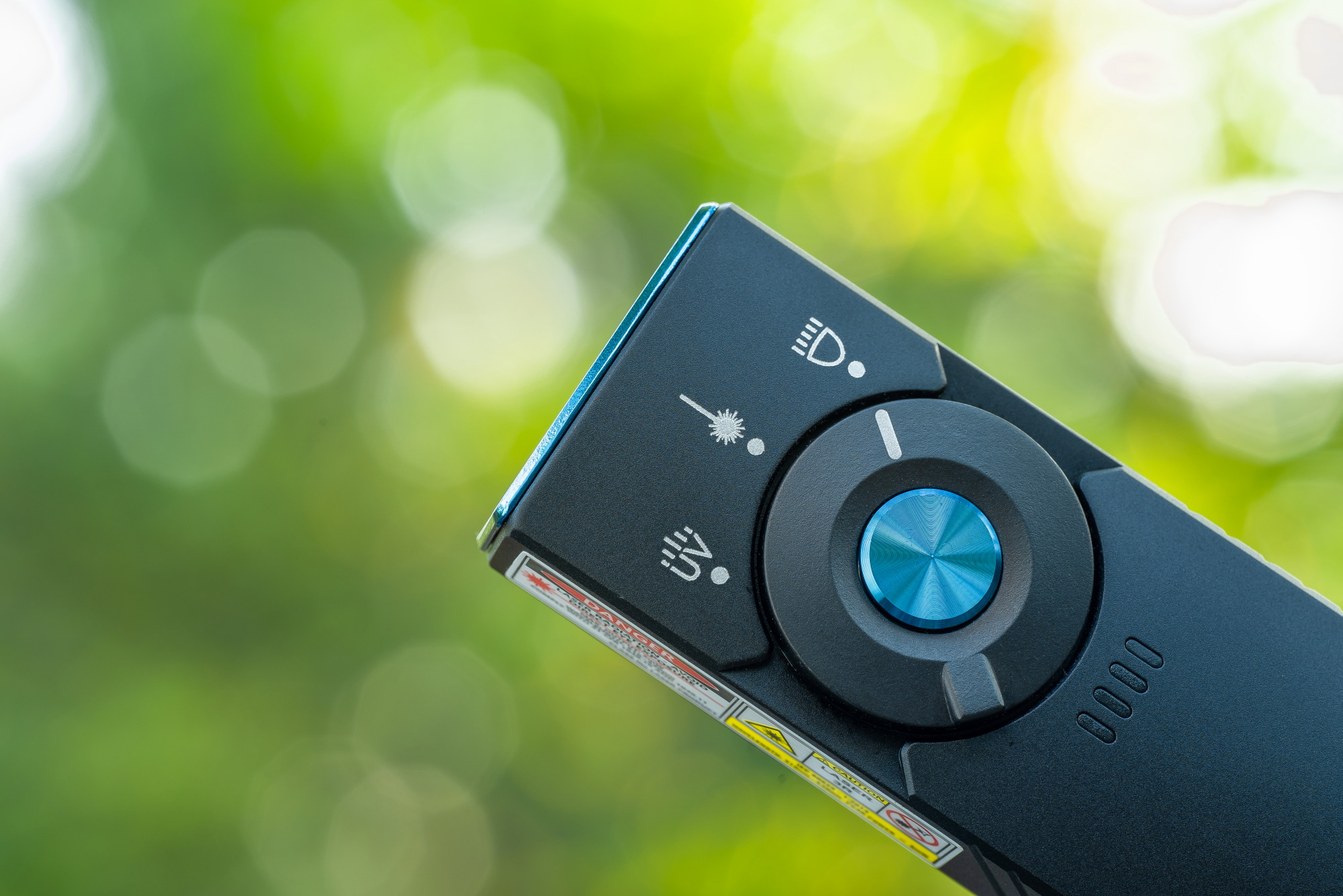 多機能ライトのクローズアップ。懐中電灯、レーザーポインター、UVライトの切り替えが可能。キャンプやプレゼンテーションに最適。