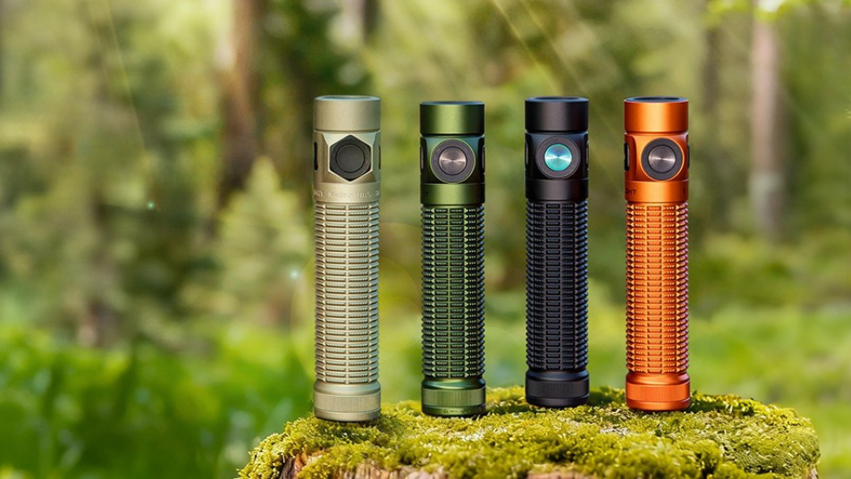 Vier leistungsstarke LED-Taschenlampen in verschiedenen Farben auf einem moosigen Baumstumpf im Wald.