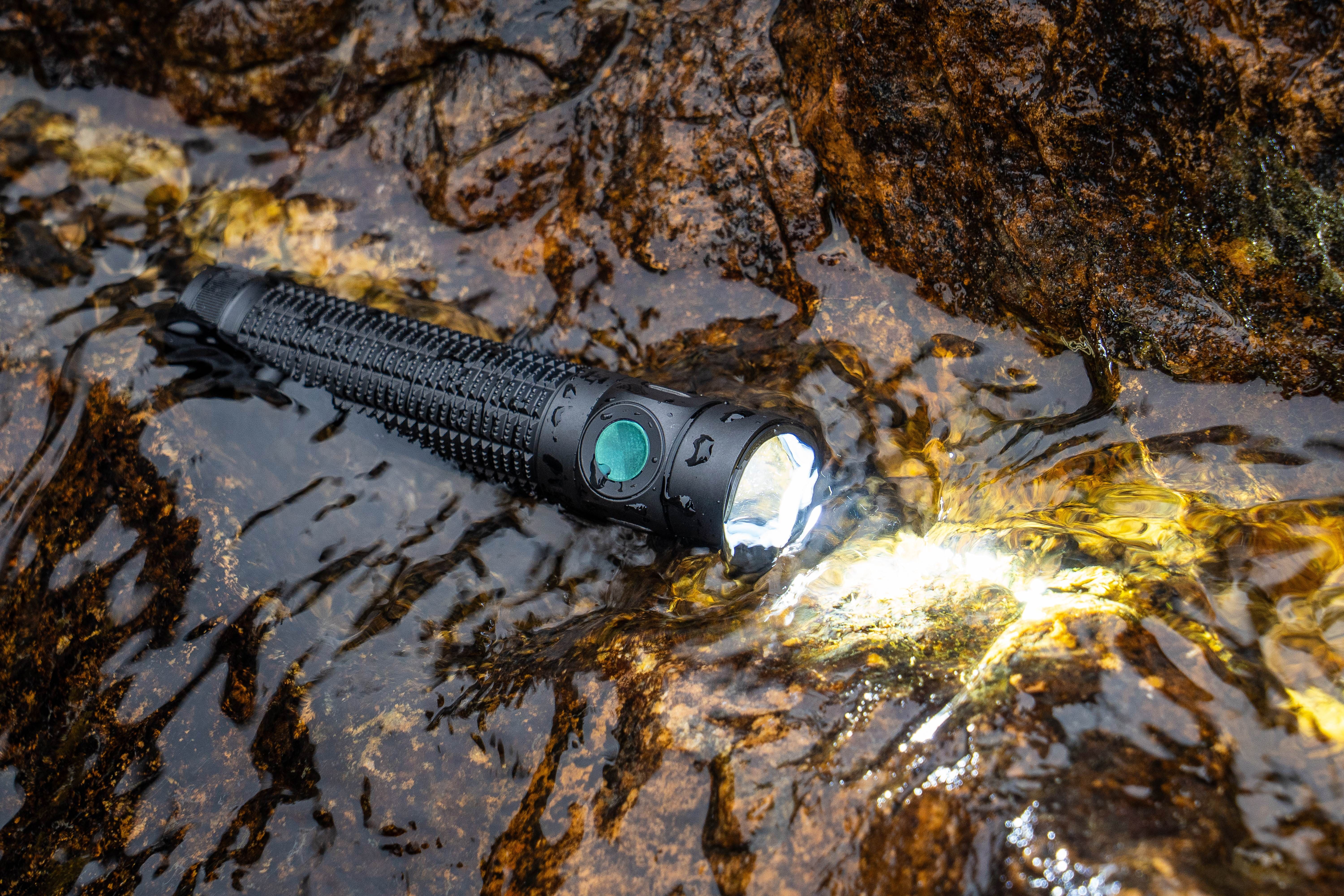 Lampe torche tactique LED noire &eacute;tanche allum&eacute;e dans l'eau