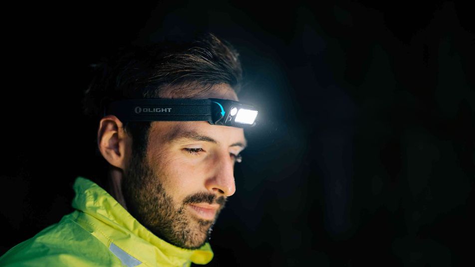 Mann mit Stirnlampe in der Nacht