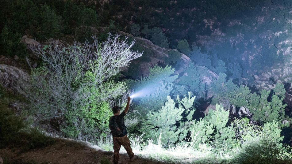 Mann geht allein mit Taschenlampe