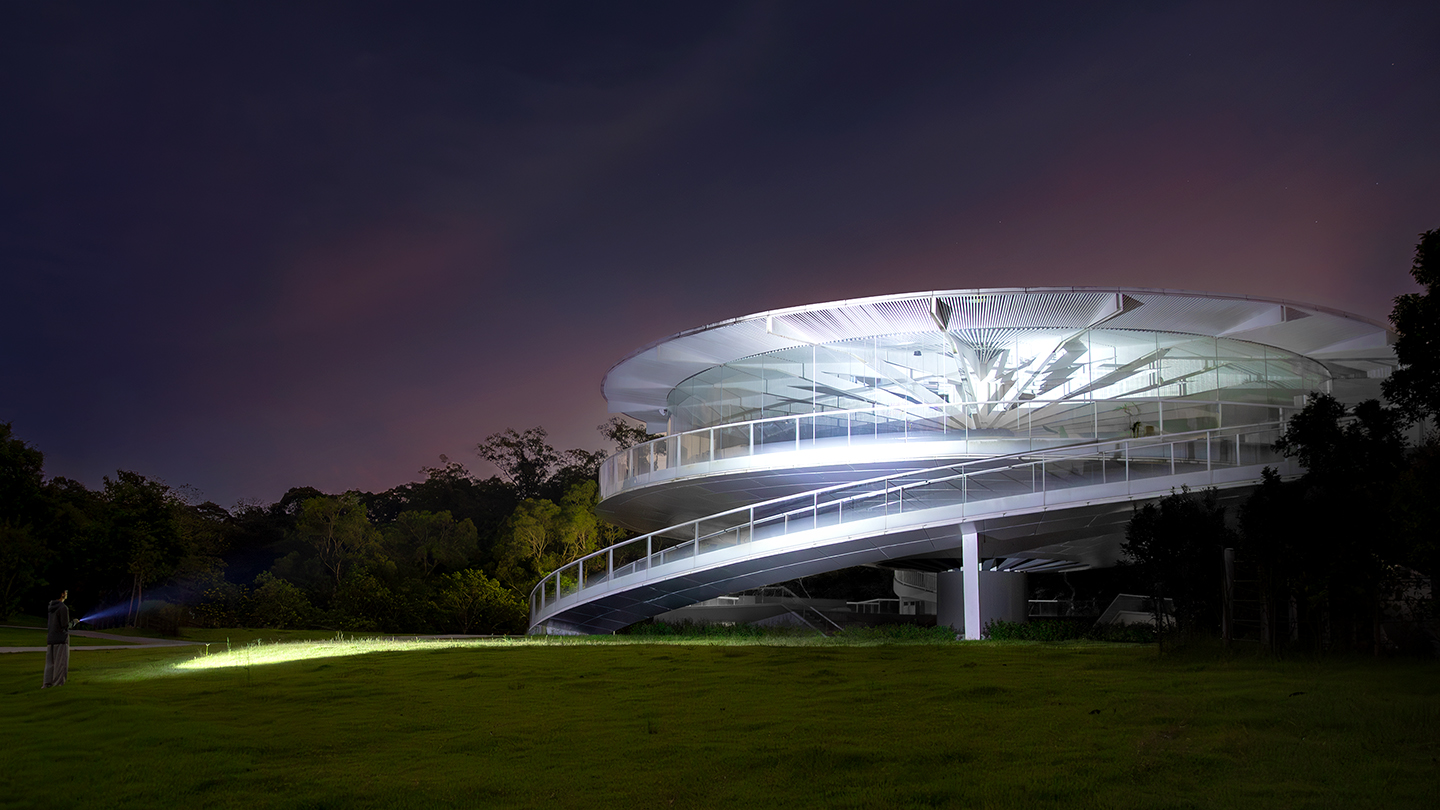 Modern circular glass building at night