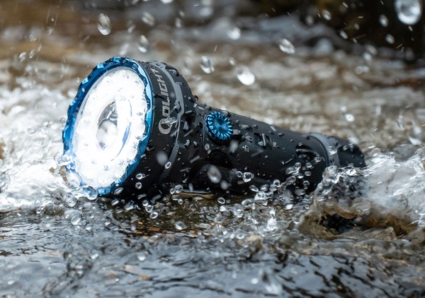 Olight waterproof tactical flashlight shining brightly in splashing water during outdoor use, demonstrating durable IPX8 water resistance for camping and hiking.