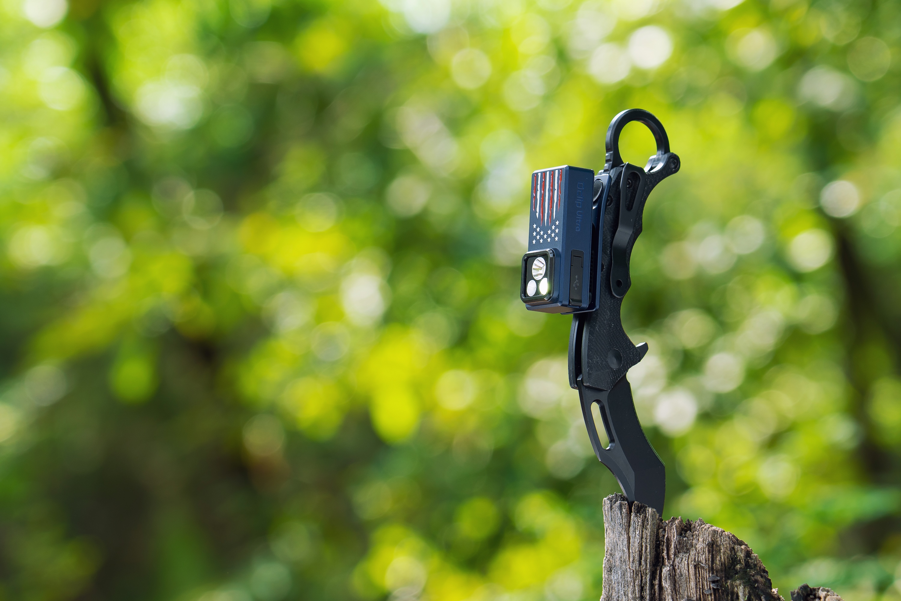 야외 나무 그루터기에 꽂힌 미국 국기 디자인 휴대용 랜턴이 달린 전술 나이프