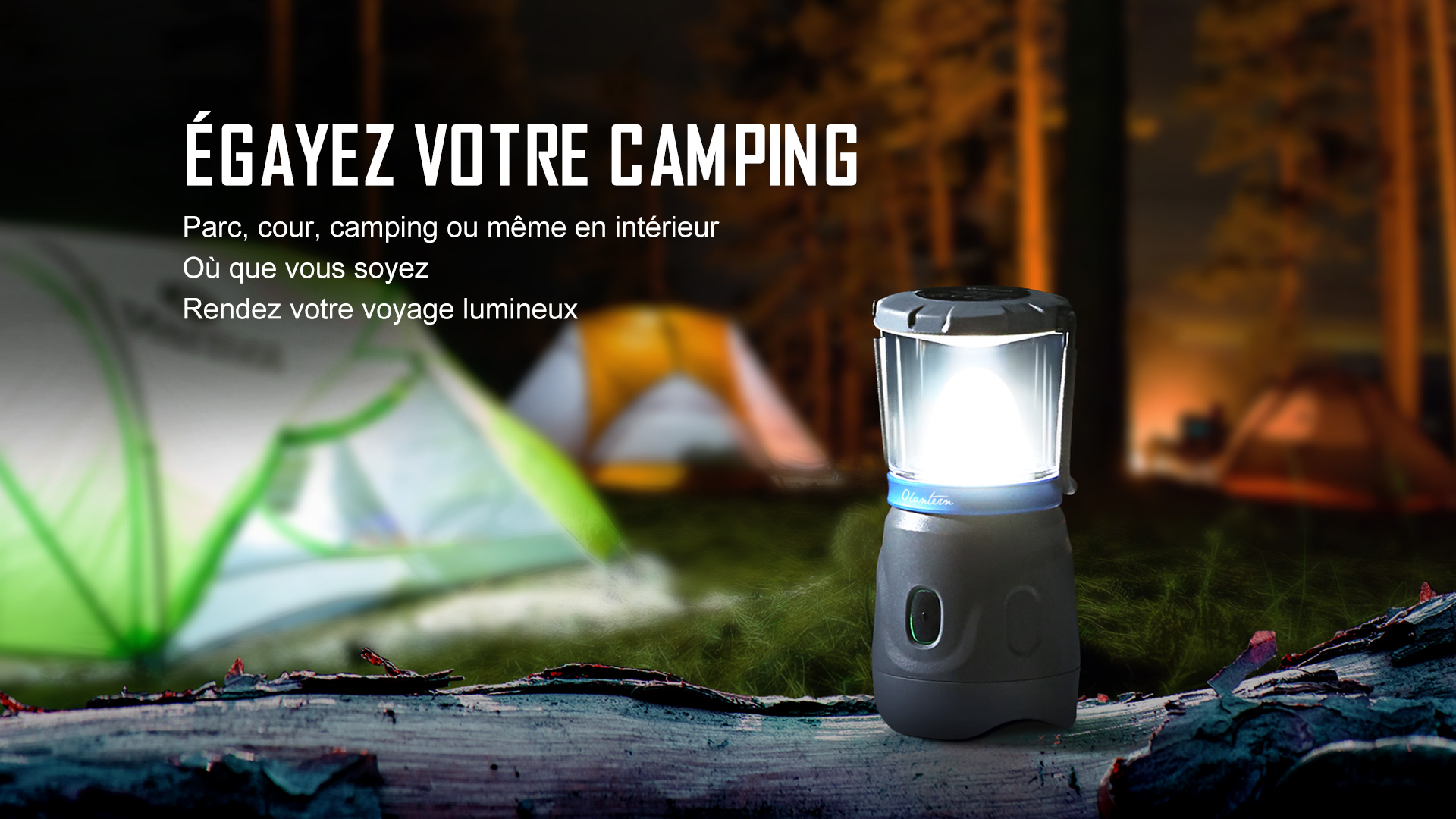 Lanterne de camping LED pos&eacute;e sur un tronc d'arbre la nuit avec tente en arri&egrave;re plan