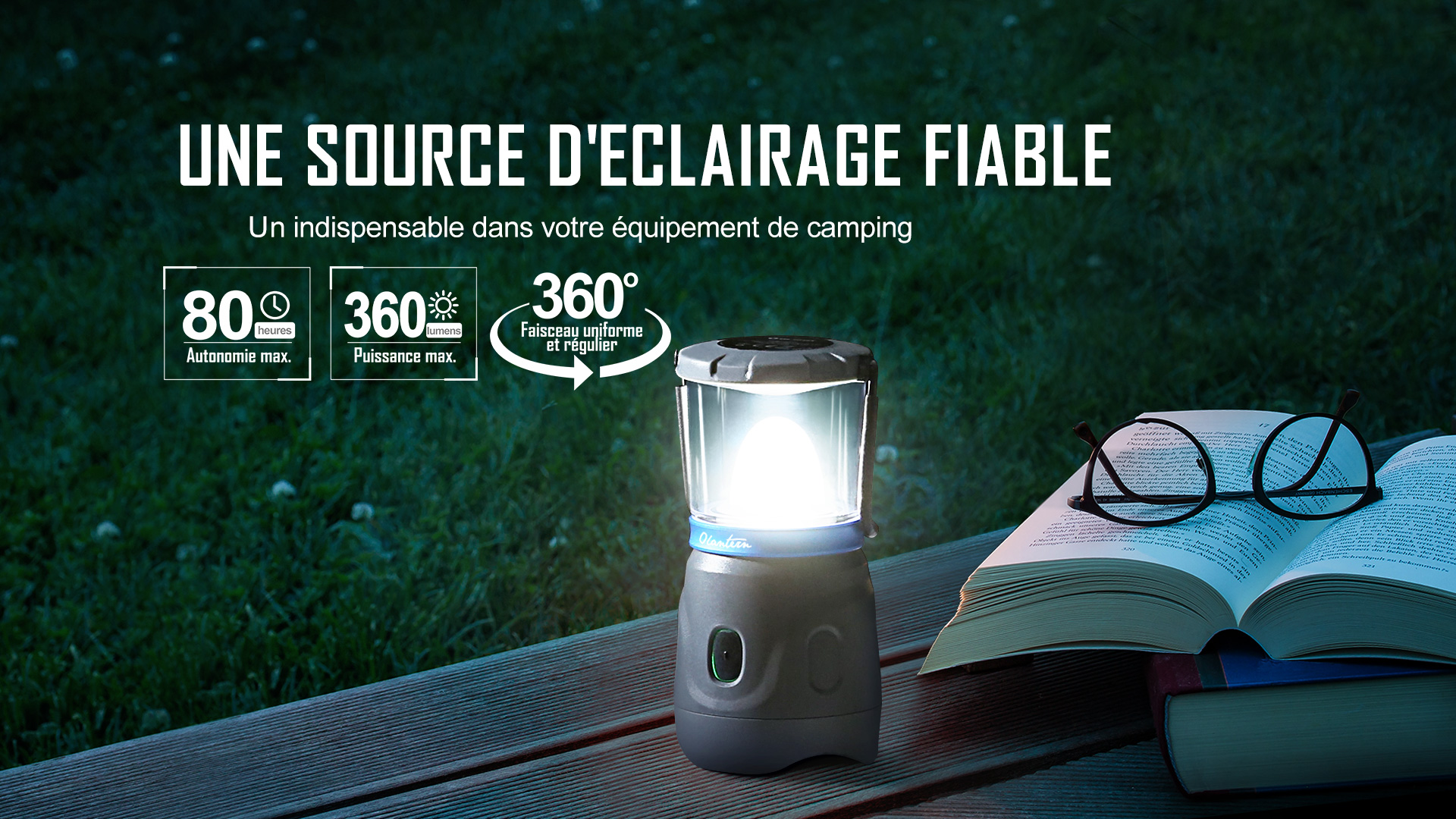 Lanterne de camping Olantern Olight allum&eacute;e sur une table ext&eacute;rieure pr&egrave;s d'un livre ouvert, &eacute;clairage LED fiable &agrave; 360 degr&eacute;s, puissance de 360 lumens et autonomie de 80 heures.