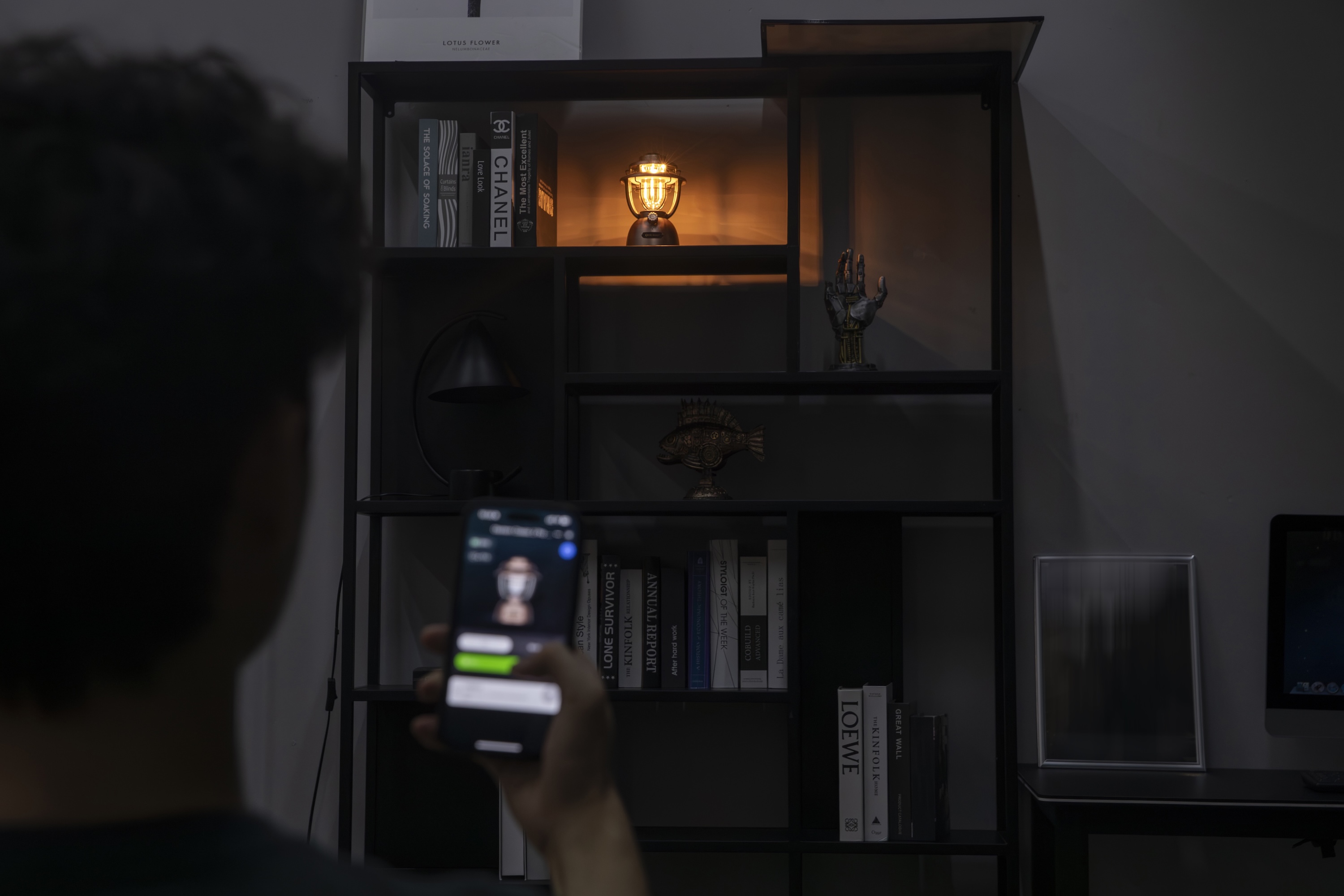 Smart home lighting control: person using a mobile app to adjust a vintage-style LED lantern.