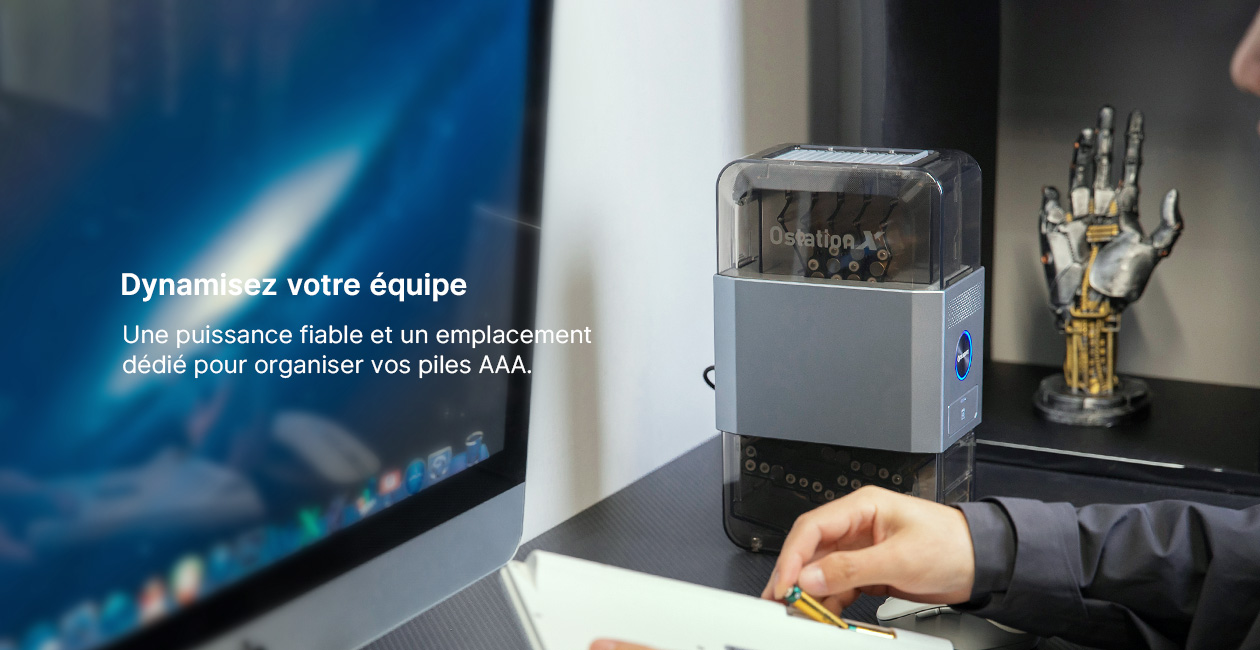 Organisateur de piles AAA Ostation sur un bureau moderne avec un écran d'ordinateur, offrant une gestion d'énergie fiable pour les équipes.