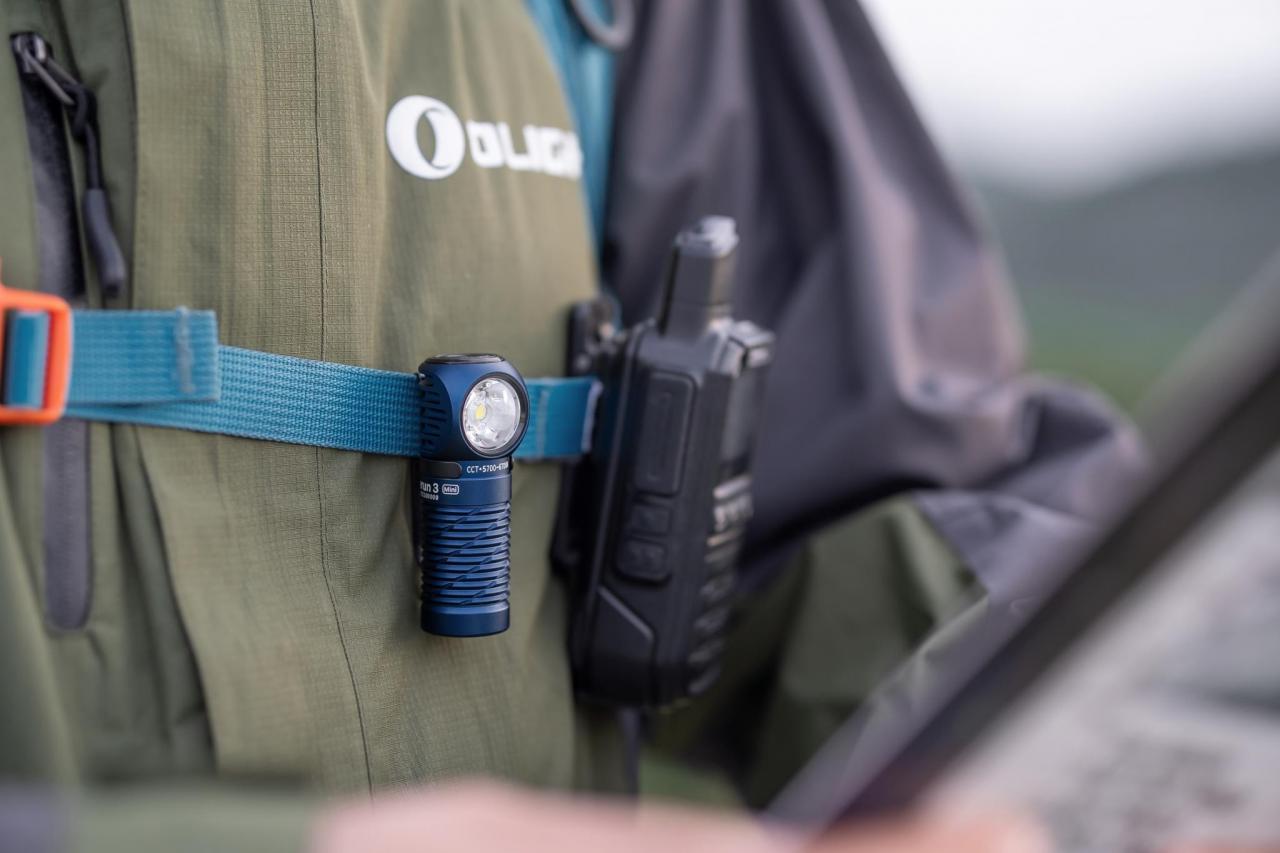Olight Perun 2 Mini compact blue right-angle flashlight clipped to a hiking backpack strap